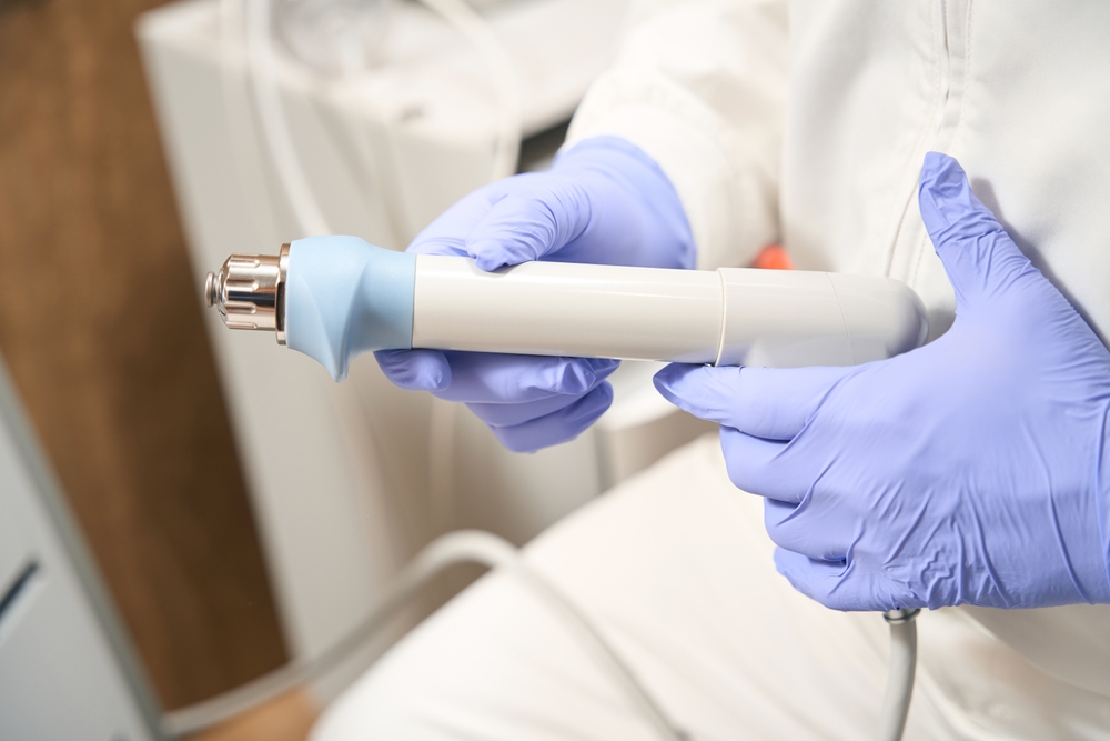 Doctor holding part of shock wave therapy device.